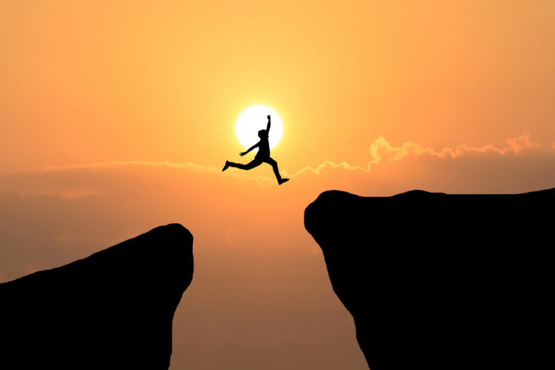 Courage man jump through the gap between hill ,Business concept